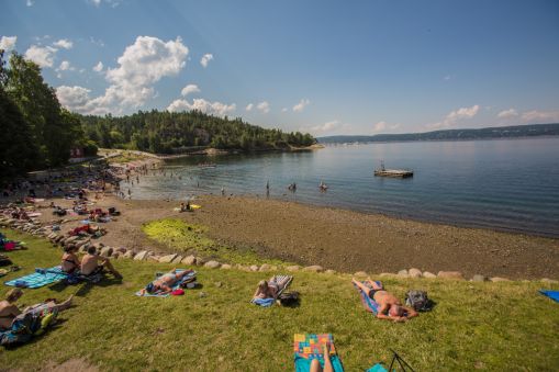 Hvervenbukta en sommerdag. Mange mennesker bader og soler seg.